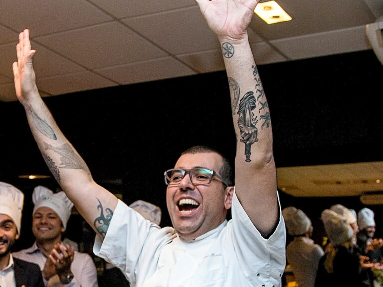 Chef comemora de braços erguidos e a equipe aplaude no encerramento do evento corporativo