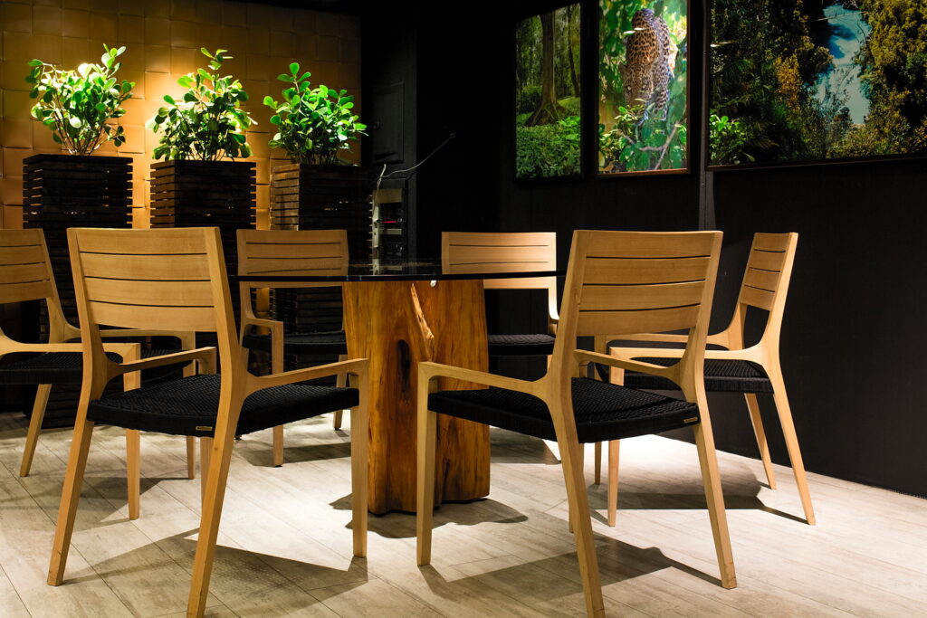 Sala reservada do Amazônia Gourmet com mesa de tronco, cadeiras de madeira clara e painéis da floresta amazônica