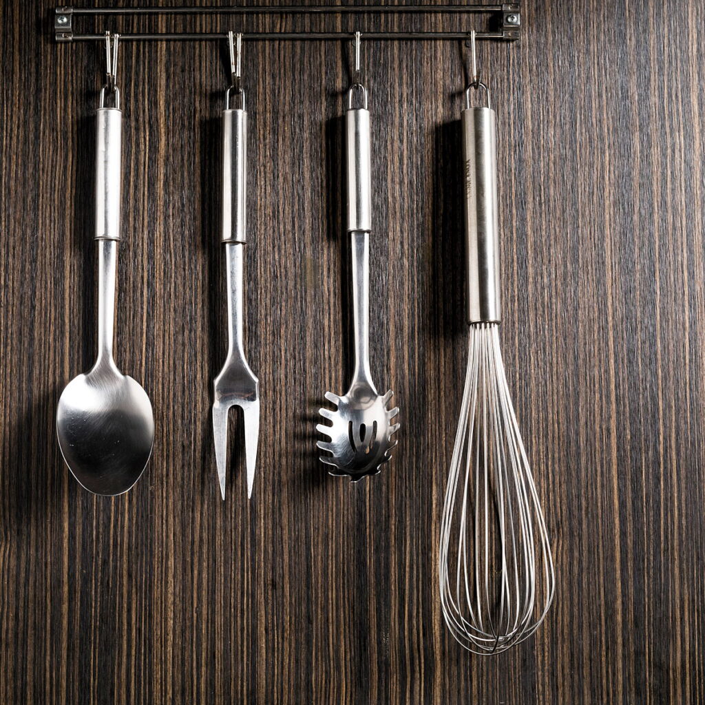 Utensílios de inox pendurados na parede de madeira ripada do Amazônia Gourmet