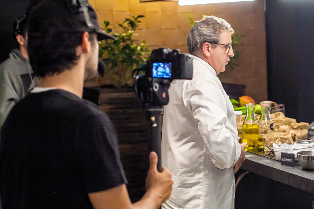 Gravação em andamento no Amazônia Gourmet: operador filma o chef na bancada, com azeites e ingredientes na frente da câmera