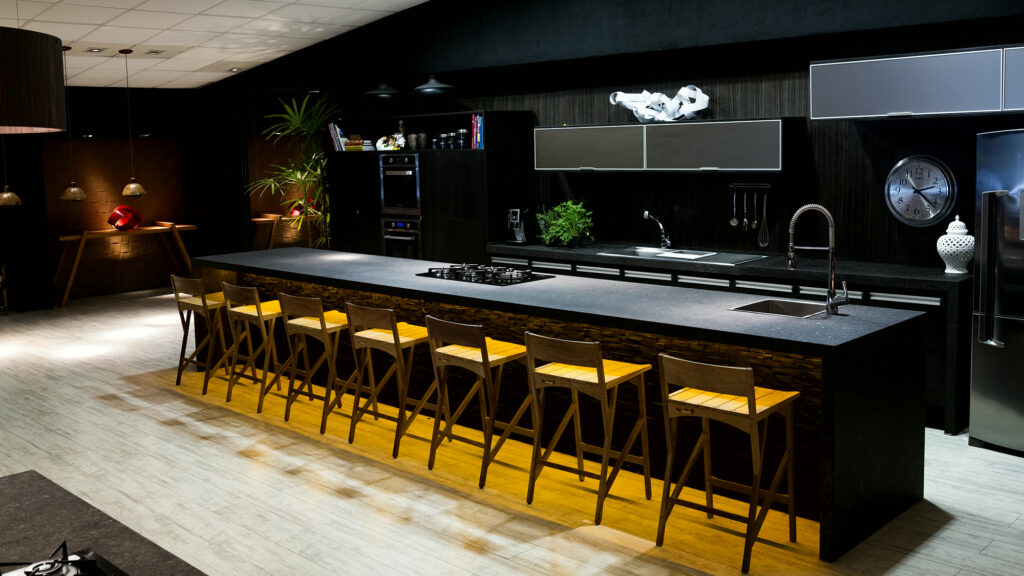 Bancada principal do Amazônia Gourmet com cooktops profissionais e banquetas em volta